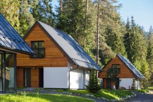 a home with a garage and a gambrel roof at VESPERA SK - Chaty Jasna - Silent place - Unique design in Liptovský Mikuláš +9 photos