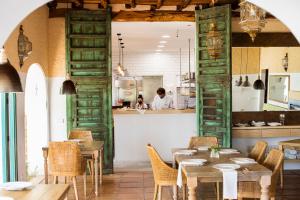 ein Restaurant mit Holztüren und Tischen sowie einer Küche in der Unterkunft Cas Gasi in Santa Gertrudis