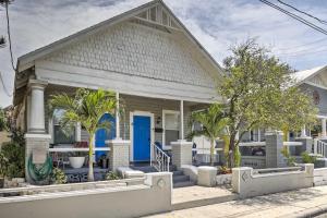 a house with a blue door and palm trees at Updated Ybor City House with Fenced Yard in Tampa