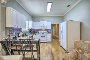 a kitchen with white cabinets and a table and chairs at Updated Ybor City House with Fenced Yard in Tampa