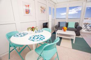 a living room with a table and chairs and a couch at Arinaga Colors, tu casa en la playa in Arinaga