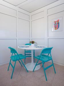 a table with two chairs and a table with a vase on it at Arinaga Colors, tu casa en la playa in Arinaga
