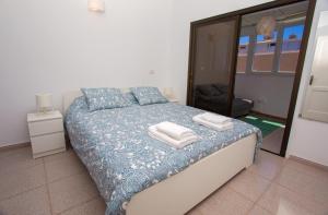a bedroom with a bed with towels on it at Arinaga Colors, tu casa en la playa in Arinaga