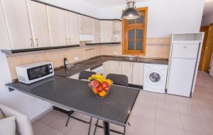 a kitchen with a table with a bowl of fruit on it at Arinaga Colors, tu casa en la playa in Arinaga