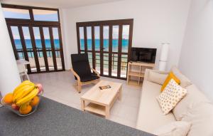 a living room with a couch and a table with bananas at Arinaga Colors, tu casa en la playa in Arinaga
