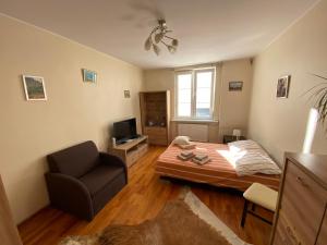 a bedroom with a bed and a chair and a television at Gdańskie Apartamenty - Apartment Superior in Old Town in Gdańsk