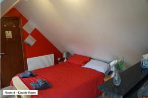 a bedroom with a red bed with two bags on it at Pentre Riding Stables in Abercraf