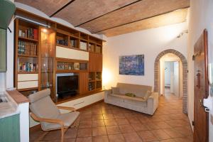 uma sala de estar com um sofá e uma televisão em Casa Siena Vallepiatta em Siena
