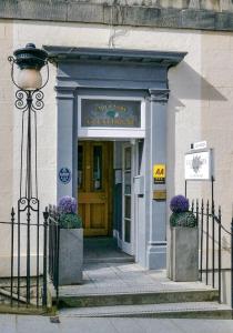een voordeur van een gerechtsgebouw met paarse bloemen bij Elder York Guest House in Edinburgh