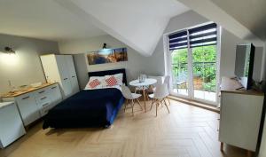 a bedroom with a bed and a table and a window at Pod Żaglami in Dąbki