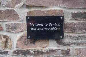 a sign on a brick wall with the words welcome to partners bed and breakfast at Pentre Riding Stables in Abercraf
