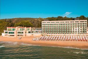 un hotel en una playa con sillas y sombrillas en Marina Hotel, Sunny Day, en Saints Constantine and Helena