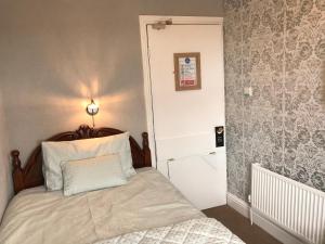 A bed or beds in a room at Norman Guest House 