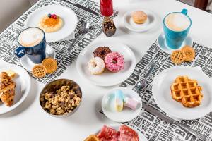 a table topped with plates of pastries and drinks at Hotel Anastasi in Cervia