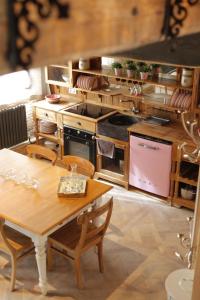 una cocina con armarios de madera y una mesa con sillas. en L'annexe du chateau des Girards, en Lans-en-Vercors