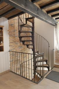 a spiral staircase in a room with a brick wall at L'annexe du chateau des Girards in Lans-en-Vercors