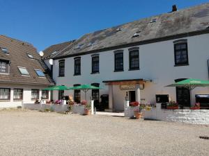 ein weißes Gebäude mit grünen Sonnenschirmen davor in der Unterkunft Hoffmanns Nordfriesisches Haus in Tönning