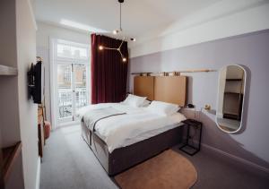 ein Schlafzimmer mit einem großen Bett und einem Spiegel in der Unterkunft The Masons Arms Hotel in Louth