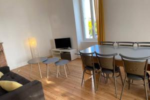 a living room with a table and chairs and a couch at Appartement lumineux Cancale, 80m2, 3 chambres. in Cancale
