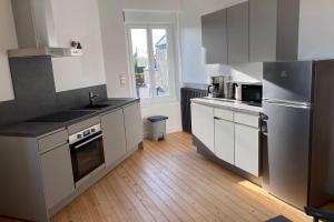 una cucina con armadietti bianchi ed elettrodomestici in acciaio inossidabile di Appartement lumineux Cancale, 80m2, 3 chambres. a Cancale