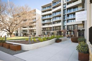 an apartment building with a sidewalk in front of it at Founders Lane Apartments by Urban Rest in Canberra