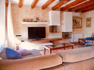 een woonkamer met een bank en een flatscreen-tv bij Casa La Luna Cambrils in Cambrils