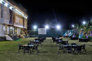 a group of tables and chairs in a field at night at HOTEL HILL VIEW in Dehradun
