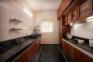 una grande cucina con armadi in legno e una finestra di Sweet Memories- Perfect home stay a Chennai