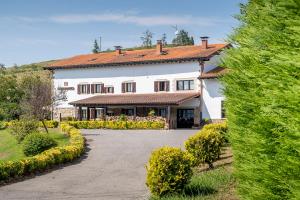 uma grande casa branca com um telhado vermelho em Astei Nekazalturismoa em Muxika