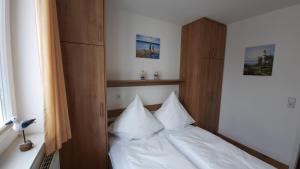 een slaapkamer met een bed met witte lakens en kussens bij Ferienwohnung Seemöwe in Großenbrode