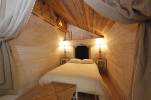 Habitación pequeña con 2 camas y paredes de madera. en L'annexe du chateau des Girards, en Lans-en-Vercors