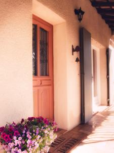 a door of a house with flowers next to it at Mas de la Croix - Chambres d'hôtes in Sernhac