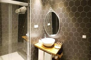 a bathroom with a sink and a mirror and a shower at Casa Rural Rojo del Tietar in La Iglesuela