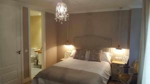 a bedroom with a large bed and a chandelier at Casa Rural Rojo del Tietar in La Iglesuela