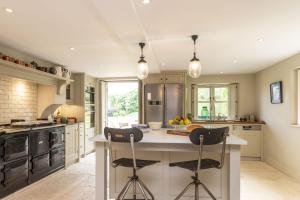 a kitchen with a large island with two bar stools at Manor Farmhouse in Dorchester