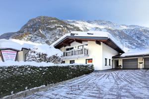 a house in the snow with a mountain in the background at Fiegl Alois in Längenfeld