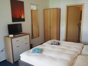 ein Schlafzimmer mit einem Bett, einem TV und einem TV. in der Unterkunft Messe Motel Laatzen in Hannover