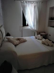 una camera da letto con un grande letto bianco con asciugamani di Il Vicolo di Ripa B&b a Ripatransone