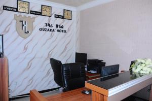 Guzara Hotel Addis في أديس أبابا: مكتب مع كراسي وساعة على الحائط