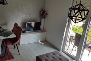a room with a desk with a television and a table with chairs at VIP APARTMAN 2020 in Vrnjačka Banja