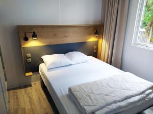 Schlafzimmer mit einem weißen Bett und einem Fenster in der Unterkunft Cap Océan in Seignosse