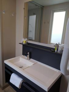 a bathroom with a white sink and a mirror at Cap Océan in Seignosse