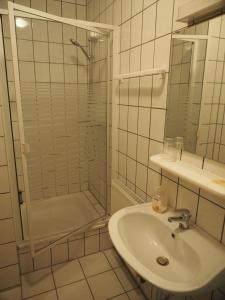 ハノーファーにあるMesse Motel Laatzenの洗面台とシャワー付きの白いバスルーム +12枚の写真