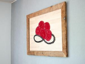 a picture of a crocheted clover in a wooden picture frame at Vordersbergerhof in Hausach