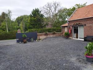a gravel driveway in front of a brick house at Studio Les chambres de la source - Tadorne in Sancourt