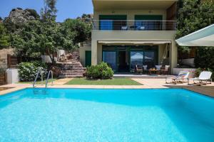 a swimming pool in front of a house at Eucalyptus Villa in Aegina Town