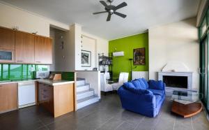 a living room with a blue couch and a kitchen at Eucalyptus Villa in Egina