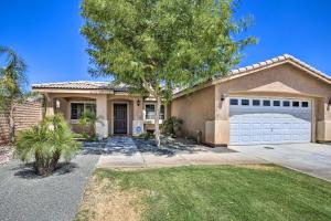 a house with a garage and a tree at Coachella Retreat Pool, Near Music Festivals in Coachella