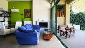a living room with a blue couch and a fireplace at Eucalyptus Villa in Aegina Town