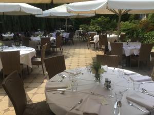 ein Restaurant mit weißen Tischen und Stühlen und weißen Sonnenschirmen in der Unterkunft Hotel Steensel in Steensel